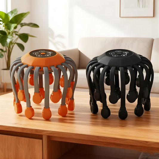 Two scalp massagers on a wooden surface, one black and gray, the other black and orange with orange massage nodes